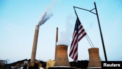 The American flag flies on a towboat as it passes Mitchell Power Plant, a coal-fired power plant, on the Ohio River in Moundsville, West Virginia, U.S., Sept. 10, 2017. 