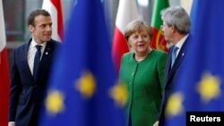 French President Emmanuel Macron, Germany's Chancellor Angela Merkel and Italy's Prime Minister Paolo Gentiloni arrive at a European Union heads of state informal meeting in Brussels, Belgium, Feb. 23, 2018.
