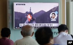 FILE - People watch a TV news program showing a file footage of North Korea's ballistic missile that the North claimed to have launched from underwater, at a Seoul railway station in Seoul, South Korea, Aug. 24, 2016.