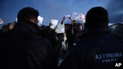 Afghan refugees stage a rally demanding to be allowed by the Greek police to reach the borderline with Macedonia, near the northern Greek village of Idomeni, on Sunday, Feb. 21, 2016.