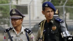 Cambodian police and soldiers look on outside during a hearing at the U.N.-back genocide tribunal.
