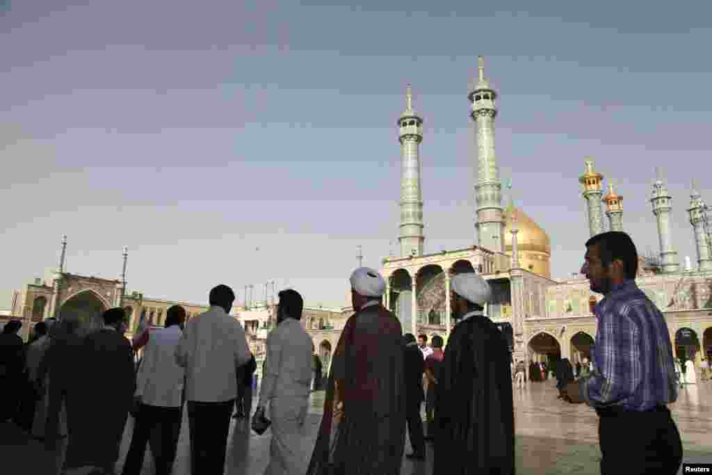 Men stand in line to vote during the Iranian presidential election at a mosque in Qom, June 14, 2013. 