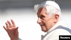 Pope Benedict XVI waves to the faithful as he arrives in St Peter's Square to hold his last general audience at the Vatican, February 27, 2013.