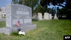 A flag is placed at the base of the tombstone of U.S. Navy Admiral Charles "Chuck" Larson at the U.S. Naval Academy in Annapolis, Md., on Aug. 24, 2018, near where U.S. Sen. John McCain will be buried on Sept. 2, 2018.