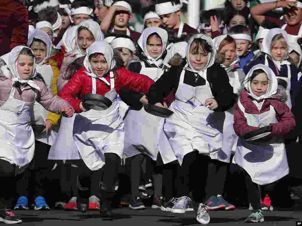 Children begin the yearly Shrove Tuesday pancake race in the town of Olney, in Buckinghamshire, England.