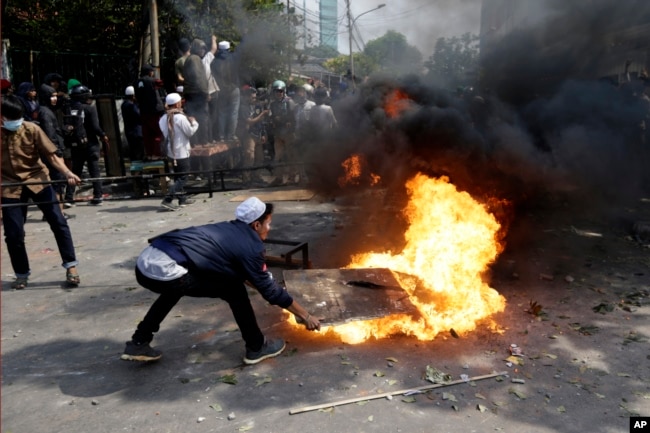 Para pengunjuk rasa mencoba memadamkan api dari ban yang dibakar dalam demo menentang hasil penetapan pilpres 2019, di Jakarta, 22 Mei 2019.