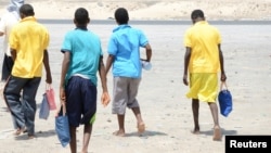 Ethiopian migrants walk after arriving to Yemen's shore on a smugglers boat in the southern province of Shabwa, Yemen, Aug. 11, 2017.