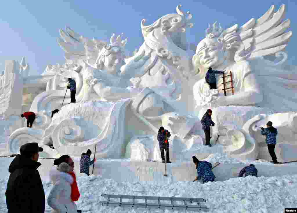 People work on a snow sculpture at the International Snow Sculpture Art Expo in Harbin, Heilongjiang province, China.