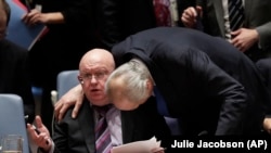 U.S. -- Russian Ambassador to the United Nations Vasily Nebenzya talks with Syrian Ambassador to the U.N. Bashar Ja'afari during a Security Council meeting, at U.N. headquarters in New York, April 10, 2018