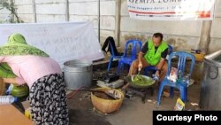 Seorang relawan pria memasak di dapur umum, sementara para ibu yang membungkus dan mengirimkan kepada para pengungsi di Lombok Barat, Sabtu, 11 Agustus 2018. (Foto: Baiq Ratu Diyah Ganefi/DPD Dapil NTB)