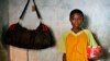 FILE - Harouna Ba, 11, a Talibe, or Islamic student, holds a begging bowl at a Dara, or Koranic school, in Pikine on the outskirts of Senegal's capital Dakar.