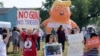 Para demonstran melakukan unjuk rasa menjelang kunjungan Presiden AS Donald Trump di lokasi penembakan massal di kota Dayton, Ohio, Rabu (7/8). 