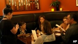 FILE - Caroline Pond takes an order last year at Park Kitchen restaurant in Portland, Oregon. (AP Photo/Don Ryan)