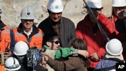 Chilean miner Edison Pena (C) hugs his wife after being brought to the surface, 13 Oct 2010 following a 10-week ordeal in the collapsed San Jose mine, near Copiapo, north of Santiago
