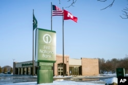 Flags fly over a First National Bank branch in Omaha, Neb., Feb. 23, 2018. The Nebraska-based First National Bank of Omaha said Thursday it will not renew its contract to issue the National Rifle Association Visa Card, spokesman Kevin Langin said in a statement.