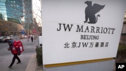 A deliveryman walks near entrance of a JW Marriott hotel in Beijing, China, Jan. 11, 2018.