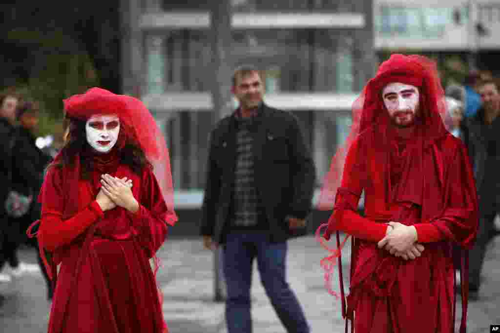 Extinction Rebellion climate change protesters call for action on climate change by staging an event against the fashion industry outside a shopping center in Istanbul.