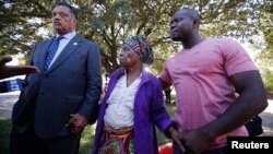 FILE PHOTO: Nowai Korkoyah, the mother of Thomas Eric Duncan, the first patient diagnosed with Ebola on U.S. soil, walks with Reverend Jesse Jackson (L) in Dallas, Texas October 7, 2014. Duncan remains in critical condition, he is on a ventilator and receiving kidney.