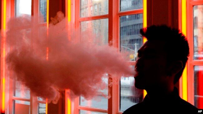 In this Feb. 20, 2014 file photo, a customer exhales vapor from an e-cigarette at a store in New York. (AP Photo)