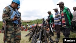 FILE - UN peacekeepers record details of weapons recovered from the Democratic Forces for the Liberation of Rwanda (FDLR) militants after their surrender in Kateku, eastern Democratic Republic of Congo, May 30, 2014.