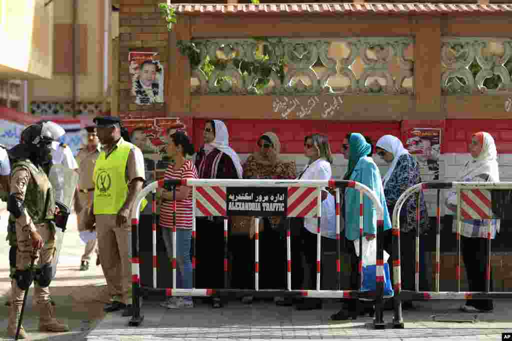 Warga menunggu giliran memberikan suara dalam pemilihan parlemen di luar sebuah tempat pemungutan suara di Iskandariyah, Mesir (18/10). ​(AP Photo/Hassan Ammar)