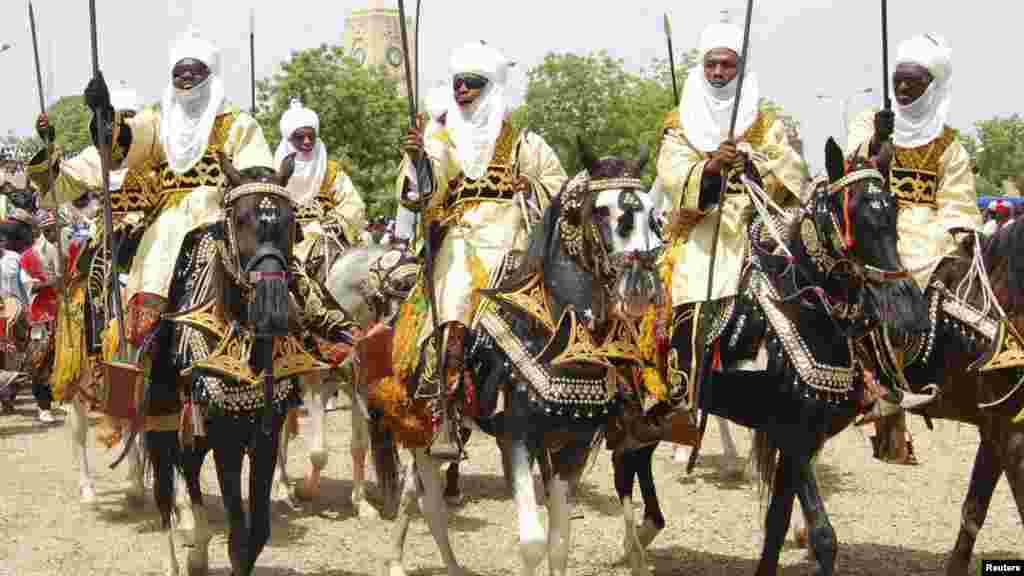 Horsemen ride their horses as they pay homage to Emir of Kano Alhaji Ado Bayero during an event marking his 50th year on the throne.