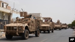 FILE - Yemeni pro-goverment forces fighting Houthi rebels are seen riding military vehicles on a street in the port city of Aden, Yemen, July 14, 2015. 