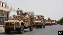 FILE - Yemeni pro-government forces fighting Houthi rebels are seen riding military vehicles on a street in the port city of Aden, Yemen, July 14, 2015. 