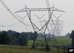 FILE - Electric lines extend over the hills of Owen County, near Owenton, Kentucky, July 22, 2011.