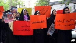 Holding anti-Saudi placards, Iranian university students attend a protest in front of the U.N. office in Tehran, Iran, April 16, 2015.