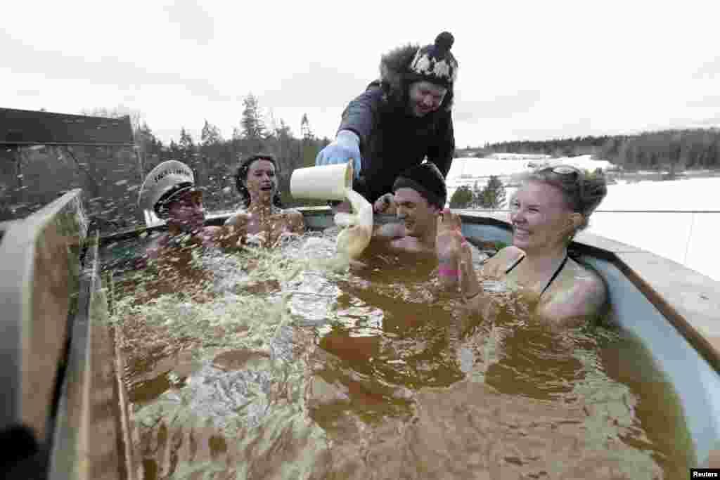A man adds beer to a hot beer bath during the Otepaa Sauna marathon in Otepaa, Estonia.
