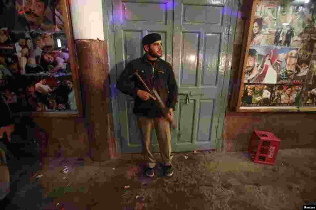 A police officer stands guard at a movie theater in Peshawar, Pakistan, Feb. 2, 2014. 