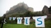 A "Yes" campaign sign for the Scottish independence referendum stands backdropped by Edinburgh Castle, in Edinburgh, Scotland, Sept. 18, 2014. 