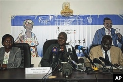 FILE - Chan Reec Madut, center, speaks during a press conference in Juba, Jan. 3, 2011.