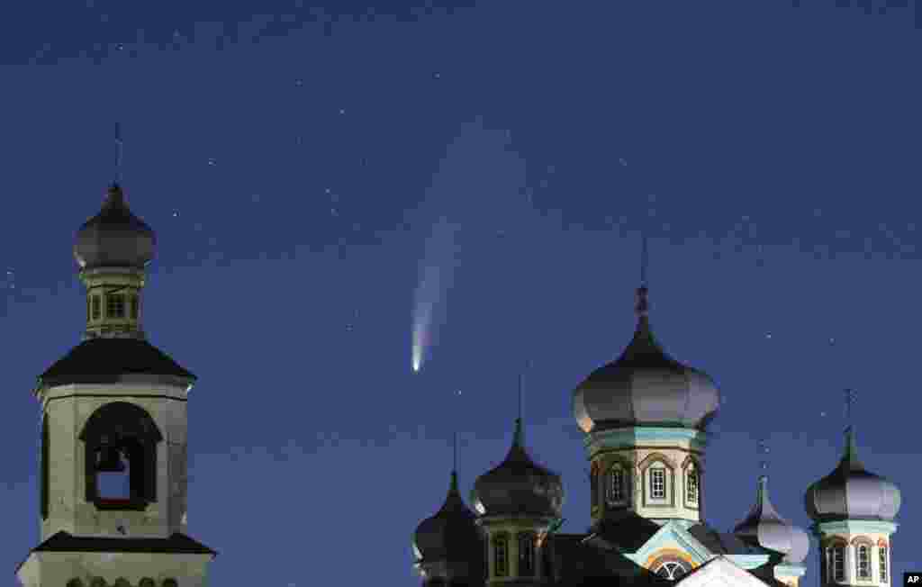 The comet NEOWISE is seen behind an Orthodox church over the Turets, Belarus, 110 kilometers west of capital Minsk.