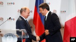 Italian Premier Matteo Renzi, right, shakes hands with Russian President Vladimir Putin at the end of a press conference at the 2015 Expo, in Rho, near Milan, June 10, 2015.