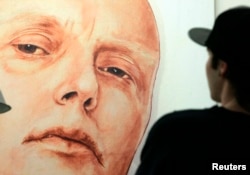 FILE - A man looks at a portrait of ex-spy Andrei Litvinenko by Russian artists Dmitry Vrubel and Viktoria Timofeyeva in the Marat Guelman gallery in Moscow.