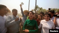 Burma pro-democracy Leader Aung San Suu Kyi poses for a photo as villagers protest against an investigation commission's report on a copper mine project in Sarlingyi township, March 14, 2013. 