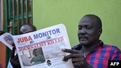 FILE - South Sudan's lawmaker Nhial Bol reads a copy of the Juba Monitor with a heading referring to the killing of South Sudanese journalist Peter Moi of The New Nation newspaper in Juba, Aug. 21, 2015 