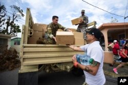 FILE - Soldiers and National Guardsmen organize aid for the Santa Ana community in the aftermath of Hurricane Maria in Guayama, Puerto Rico, Oct. 5, 2017.