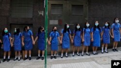 Estudiantes con máscaras se toman de las manos para rodear el St. Stephen's Girls' College en Hong Kong, el lunes 9 de septiembre de 2019.