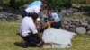 Para petugas tengah memeriksa potongan reruntuhan pesawat yang ditemukan di pantai Saint-Andre, di Pulau Reunion, Samudera Hindia (29/7).