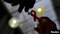 Une infirmière donne un ruban à une femme, pour la journée de lutte contre le sida, à Sao Paulo, le 1er décembre 2014.