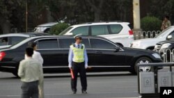 A stretch limousine believed to be carrying North Korean leader Kim Jong Il drives ahead of a convoy of cars traveling towards the Great Hall of the People in Beijing, China, May 25, 2011