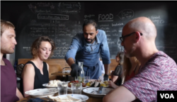 Syrian cook Abdell Baset introduces new foods to restaurant patrons.