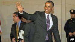 President Barack Obama waves to members of the media as he heads to a meeting with House Democratic Caucus on Capitol Hill in Washington, March 14, 2013.