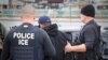 FILE - U.S. Immigration and Customs Enforcement (ICE) officers detain a suspect as they conduct a targeted enforcement operation in Los Angeles, Feb. 7, 2017. 