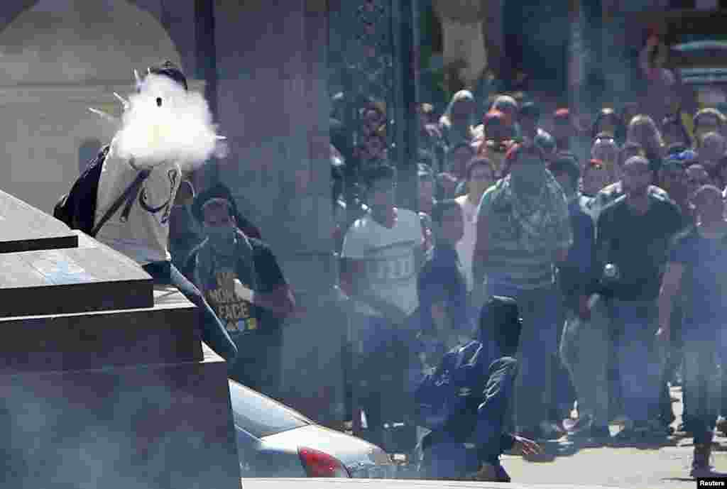 Para mahasiswa pendukung kelompok Ikhwanul Muslimin melemparkan mercon saat bentrok dengan polisi di komplek Universitas Kairo, Mesir.