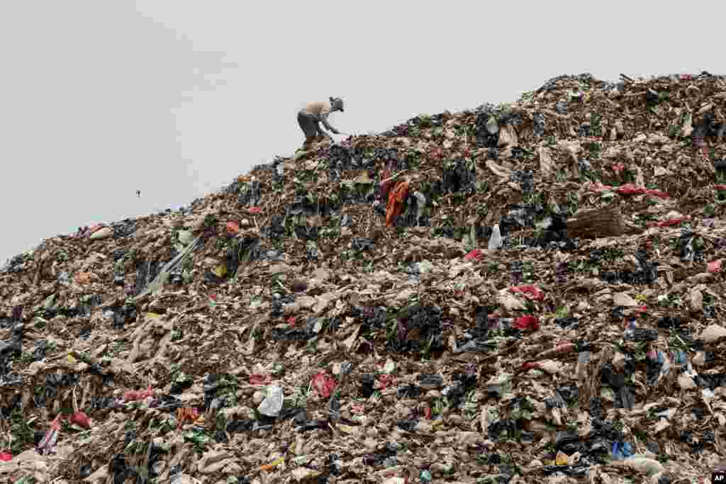 A ragpicker looks for recyclable items on a pile of garbage at a landfill in Depok, Indonesia. 