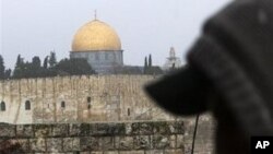 Masked Palestinian youths prepare to throw stones and firecrackers at Israeli police, not seen, as they are backdropped by the Dome of the Rock Mosque, during clashes in the east Jerusalem neighborhood of Ras Al Amud, Sunday, 28 Feb. 2010